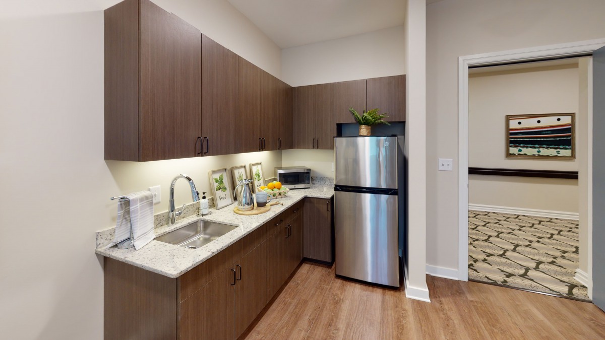 A modern kitchen with wooden cabinets, stainless steel appliances, and a clean countertop.