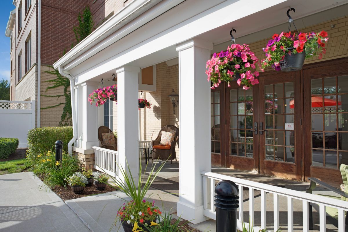 A charming porch with hanging flower baskets and comfortable seating.