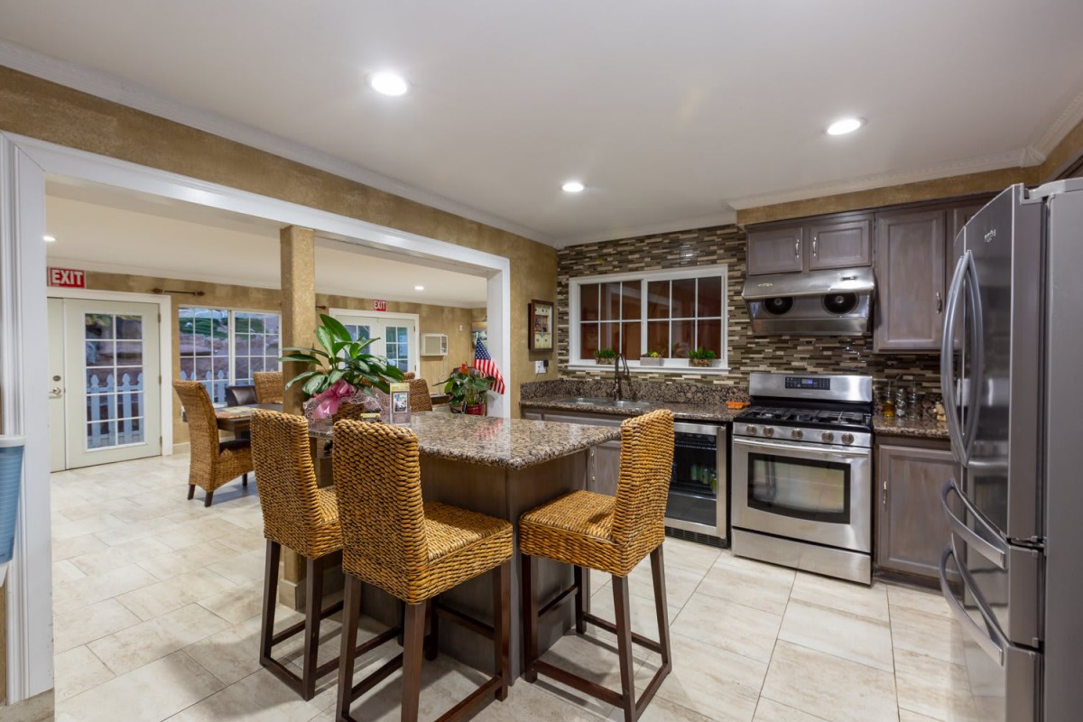 Modern kitchen with island seating and stainless steel appliances in an open layout.