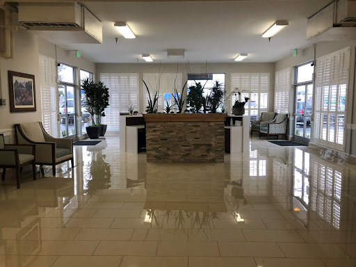 A modern lobby featuring a reception area with elegant furniture and decorative plants.