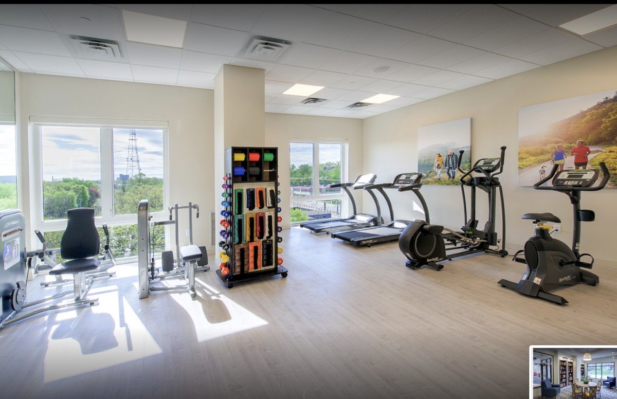 A well-lit gym featuring treadmills and various exercise equipment.