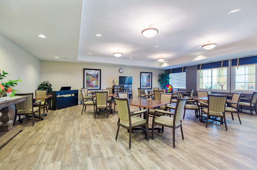 A spacious and well-lit dining area featuring wooden tables and chairs, designed for community gatherings.