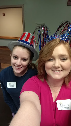Two friends enjoying a festive event with playful hats.