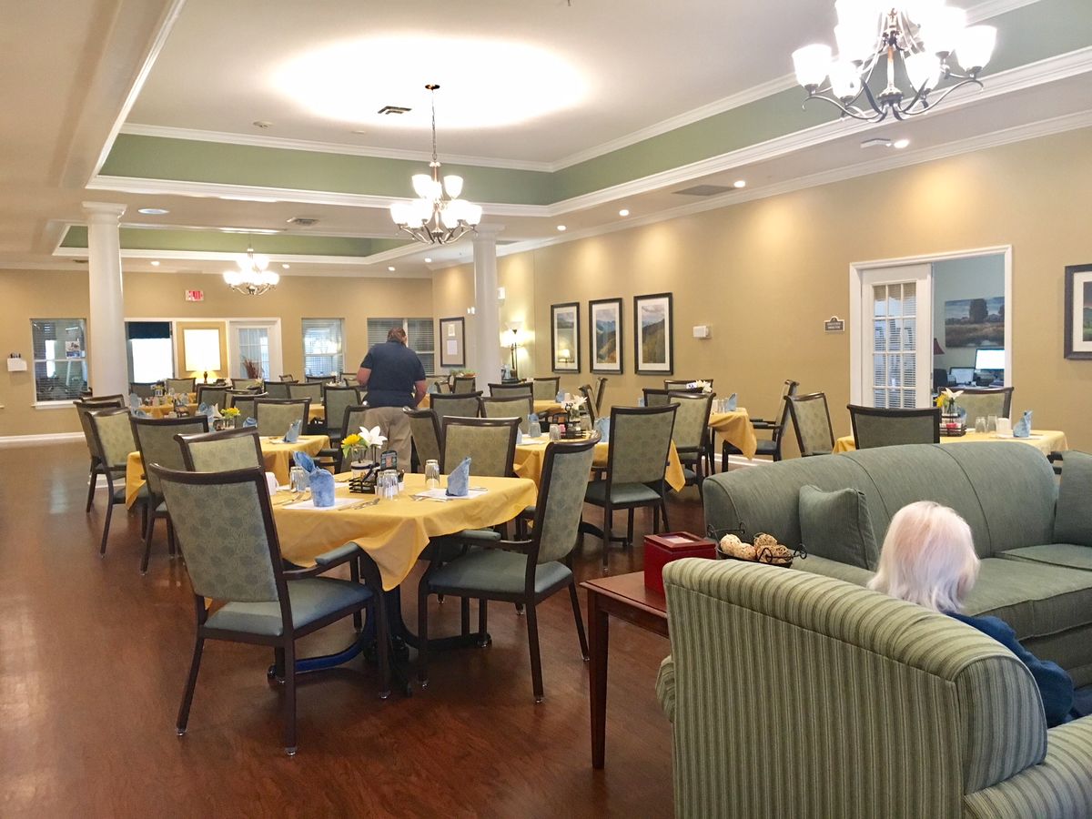 A cozy dining area with elegantly set tables and comfortable seating.