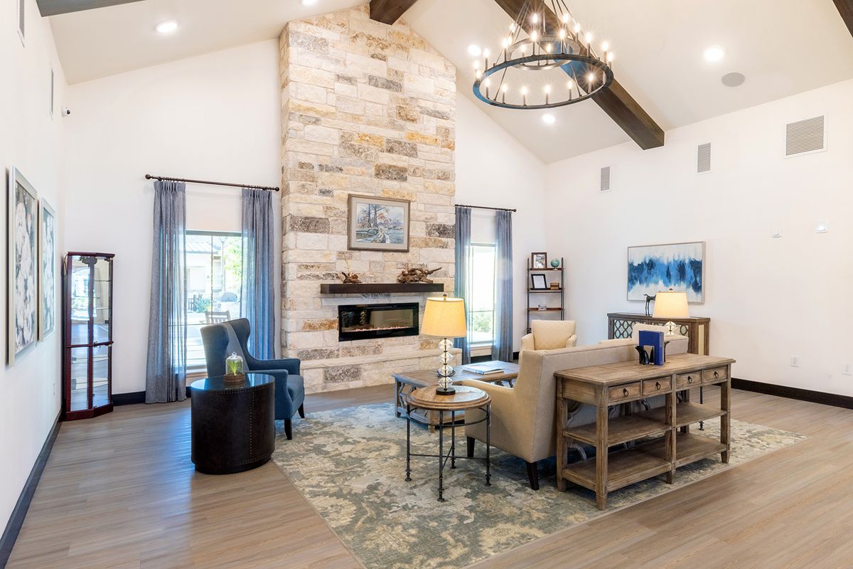 A modern living room with a stone fireplace and vaulted ceilings, featuring elegant furniture and decor.