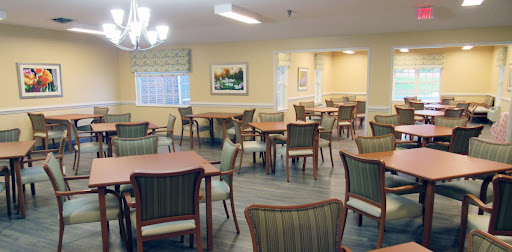 A cozy dining area featuring wooden tables and comfortable chairs, designed for community gatherings.