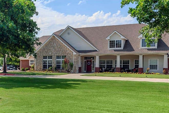 A suburban house with a well-maintained lawn and brick exterior.