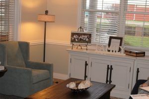 A cozy living room with a sofa, lamp, and decorative items on a sideboard.