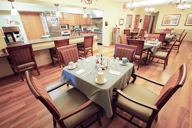 A cozy dining area and kitchen with a table set for a meal.