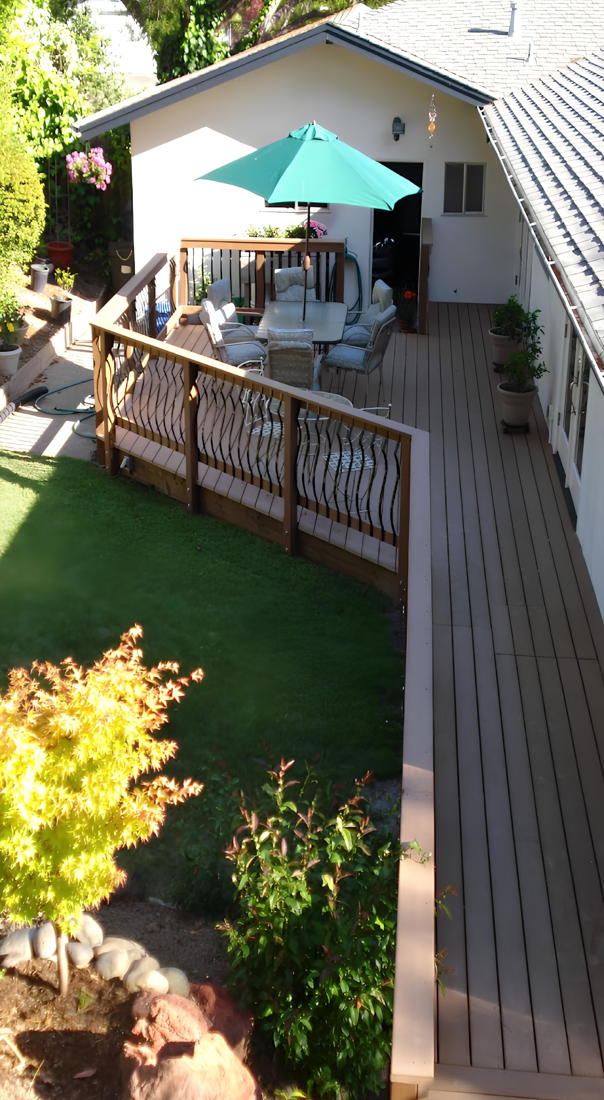 A backyard featuring a wooden deck with patio furniture and surrounding greenery.