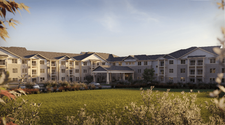 A large residential building with a well-maintained lawn and a clear sky at sunset.