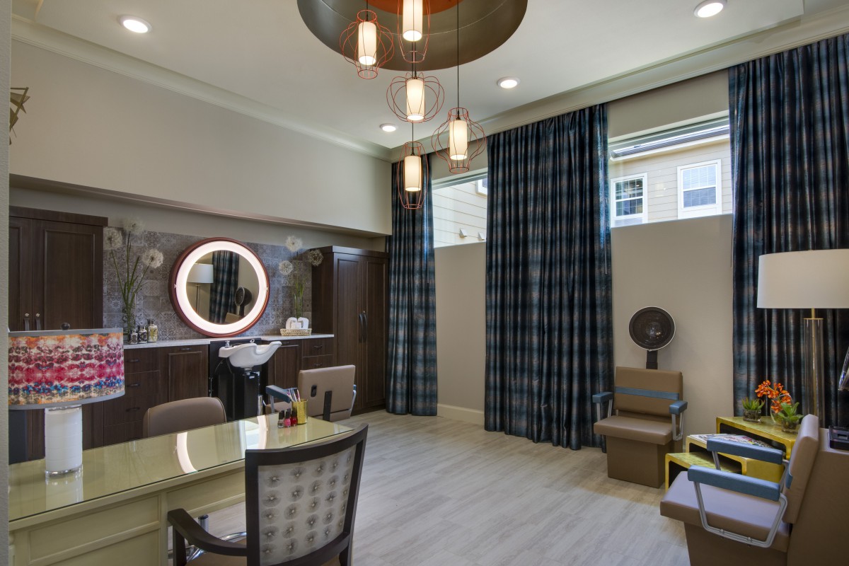 A modern salon interior featuring a hairdressing station, stylish chairs, and contemporary lighting.