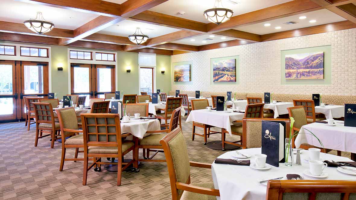 An elegant dining room with neatly arranged tables and chairs, ready for guests.