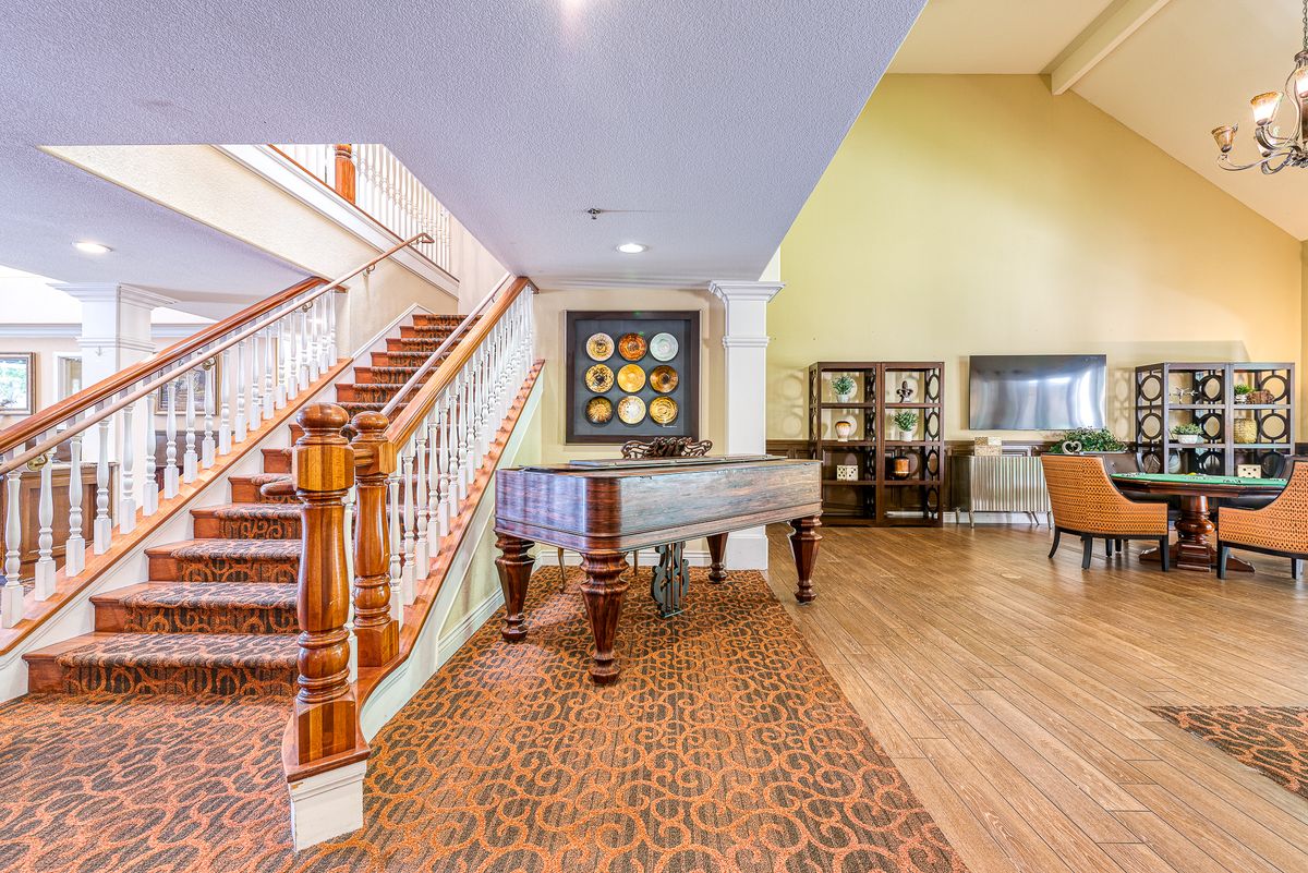 A cozy interior space featuring a staircase, foosball table, and comfortable seating.
