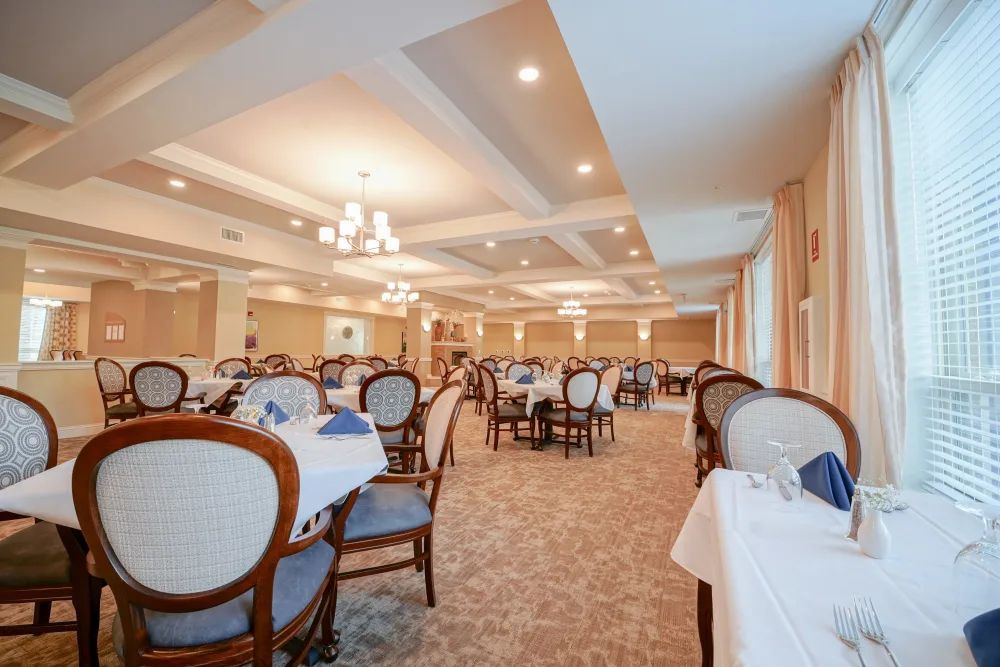 An elegant dining room with neatly arranged tables and chairs, featuring soft lighting and classic decor.