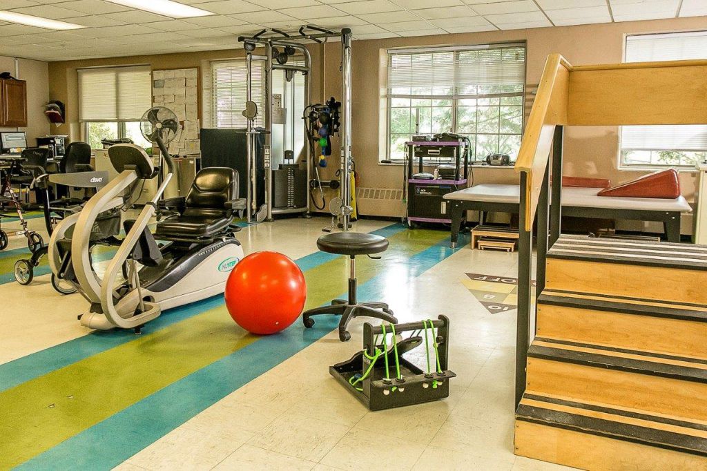 A fitness and rehabilitation area equipped with various exercise machines and therapy tools.