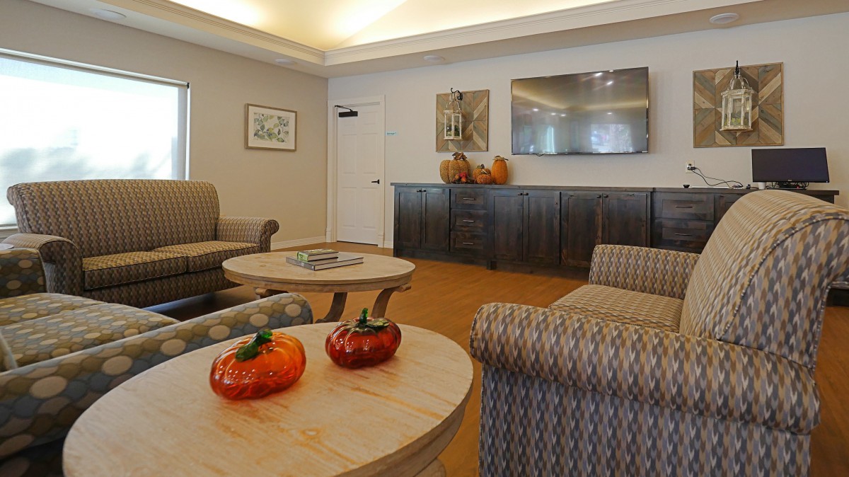 A cozy living room with autumn-themed decorations, including pumpkins on the tables.