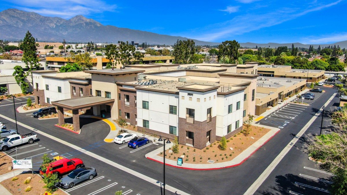 Aerial view of a modern office building with a parking lot.