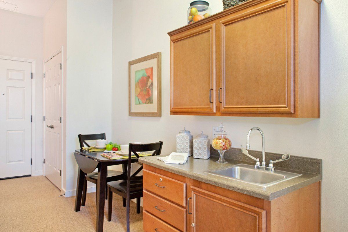 A cozy kitchen with wooden cabinets and a small dining area featuring a table and chairs.