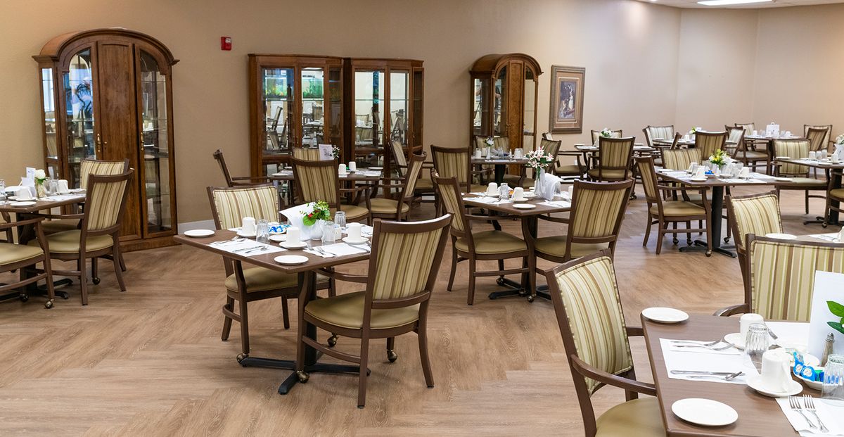 A neatly arranged dining area with tables and chairs set for a meal.