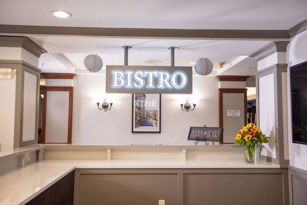 Interior view of a bistro featuring a prominent sign and warm lighting.