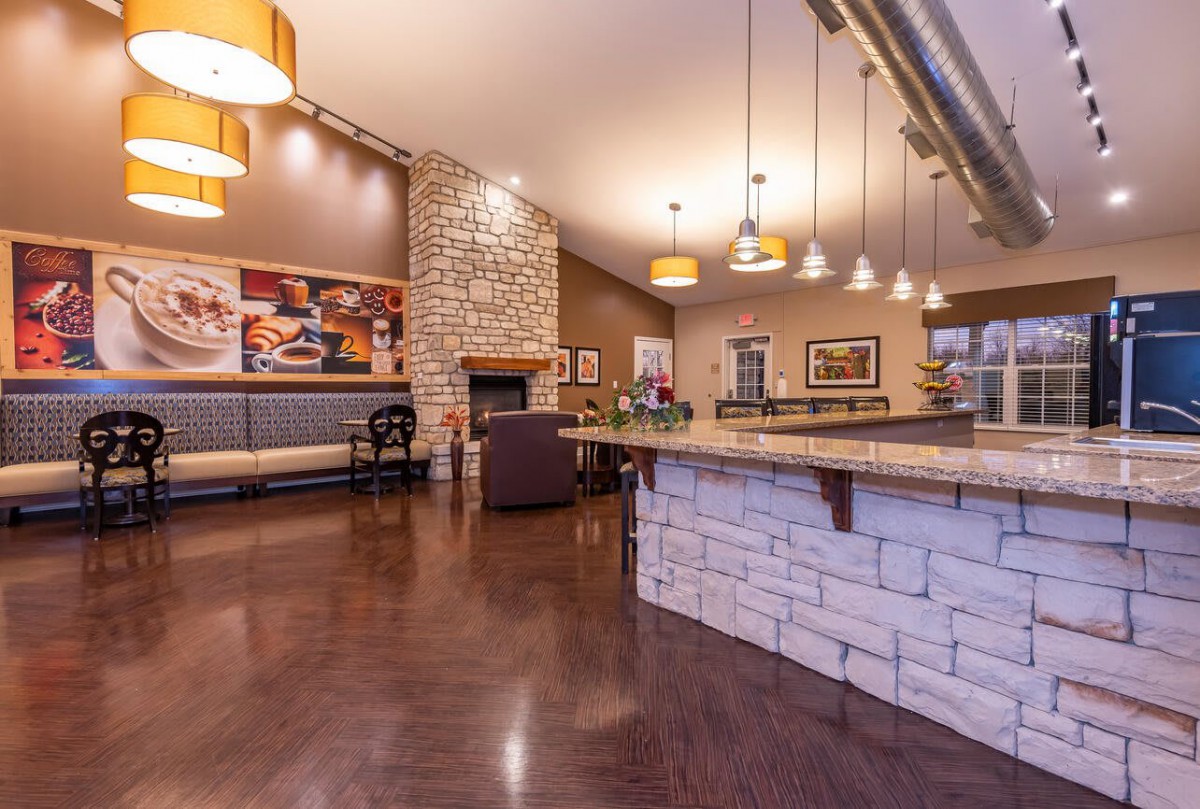 A modern lounge area with a bar, stone walls, and warm lighting.