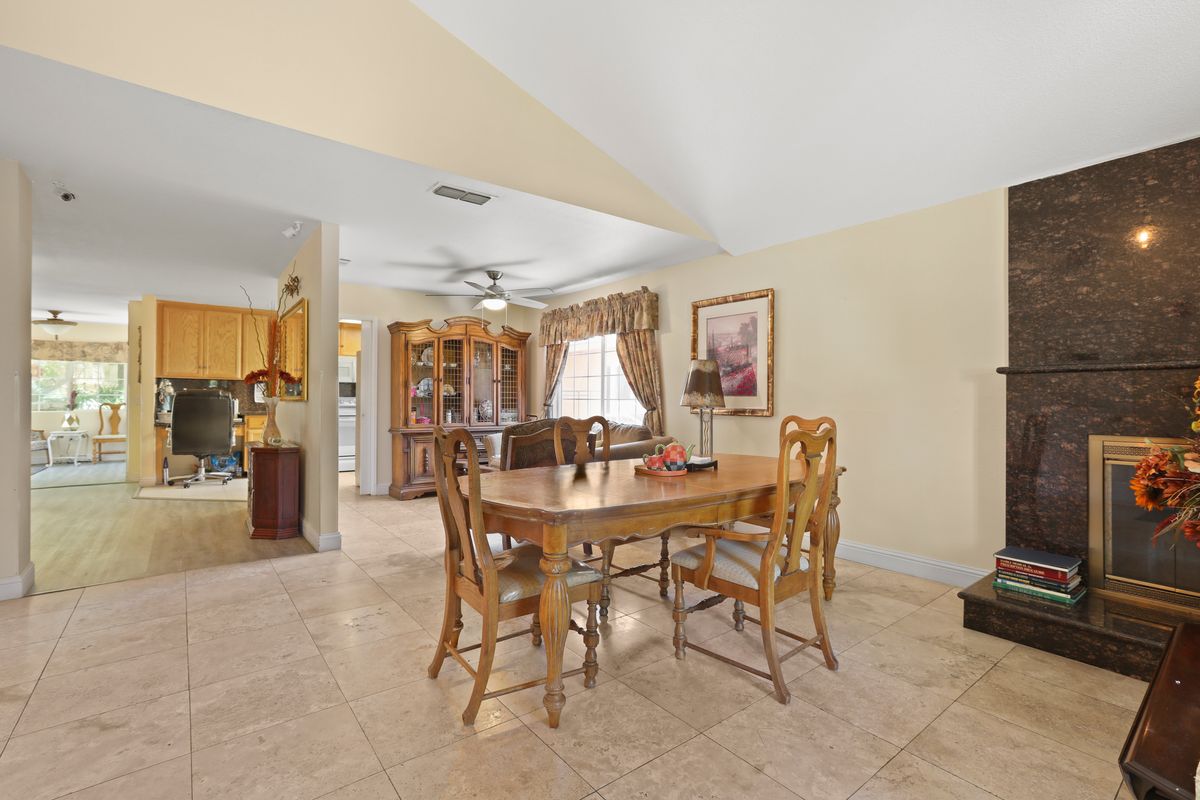 Cozy dining area with a wooden table and chairs, featuring homey decor and ample natural lighting.