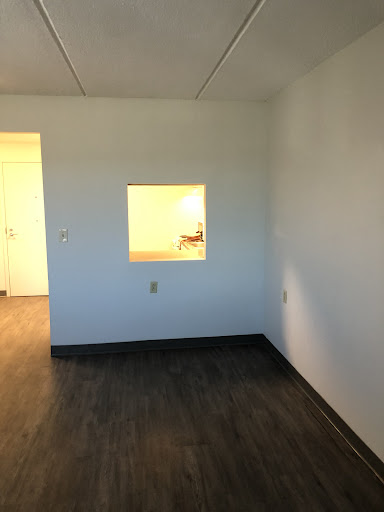 An empty room featuring a small window and minimalist design.