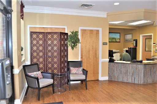 A cozy waiting area in an office featuring stylish chairs, a decorative screen, and a welcoming atmosphere.