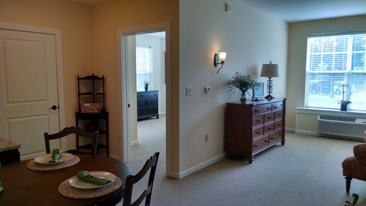 A cozy living room with warm lighting, featuring a dresser and elegant decor.