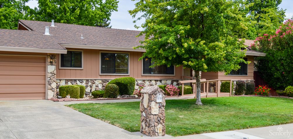 A suburban house with a landscaped front yard and a stone mailbox.