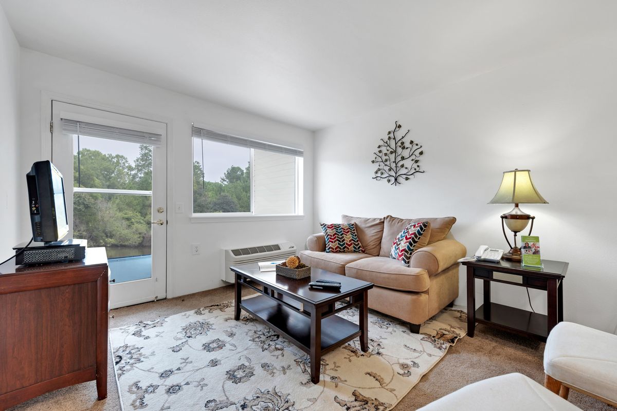 A cozy living room with a sofa, coffee table, and soft lighting.