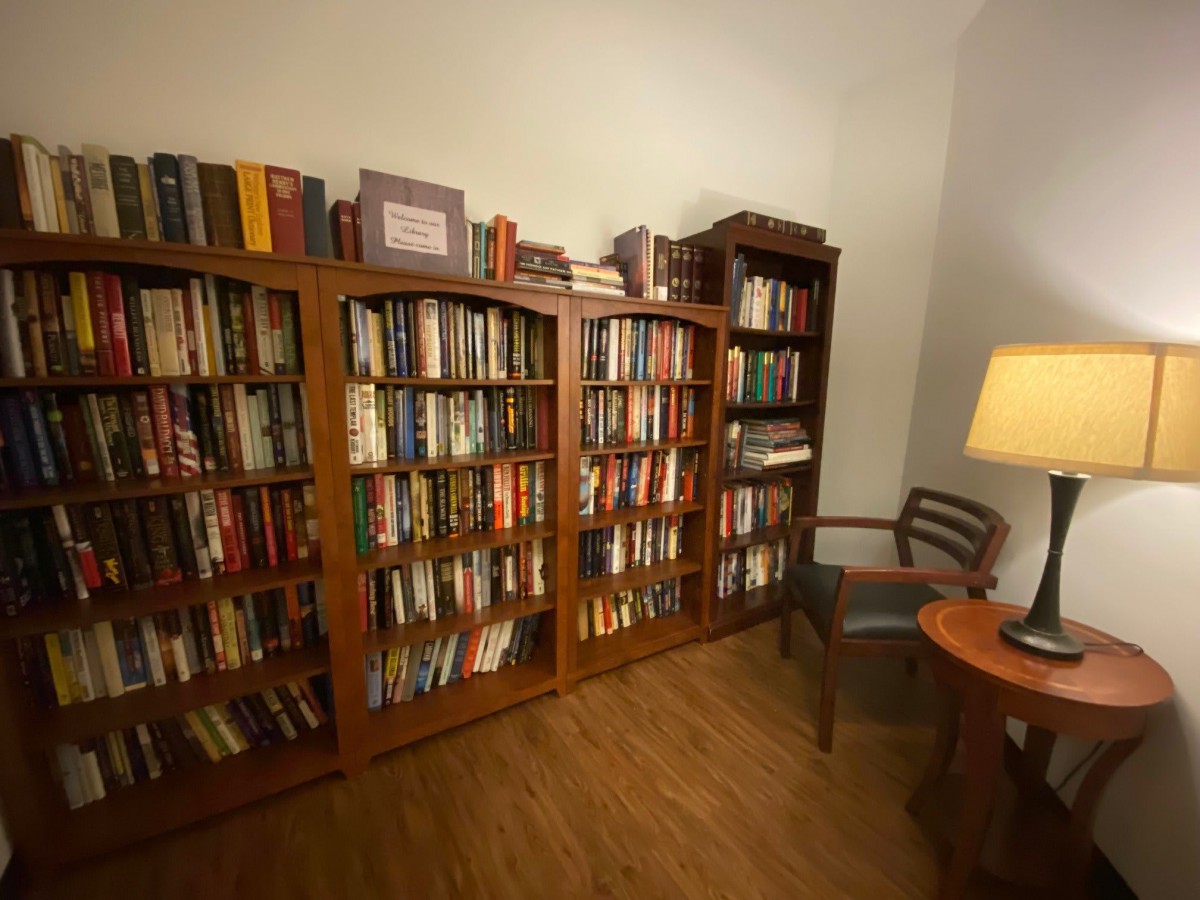 A cozy reading room with bookshelves filled with books and a warm lamp.
