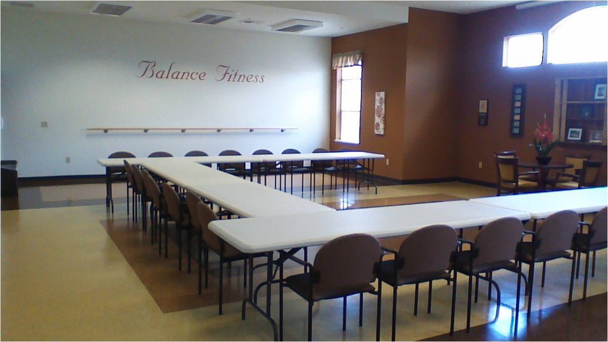 A U-shaped conference room setup with tables and chairs, ready for a meeting.