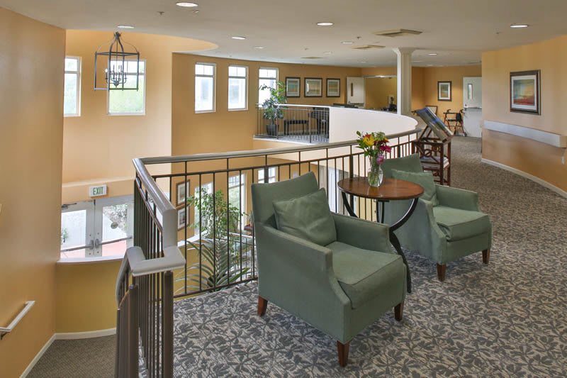 A cozy seating area with armchairs and a small table overlooking a balcony.