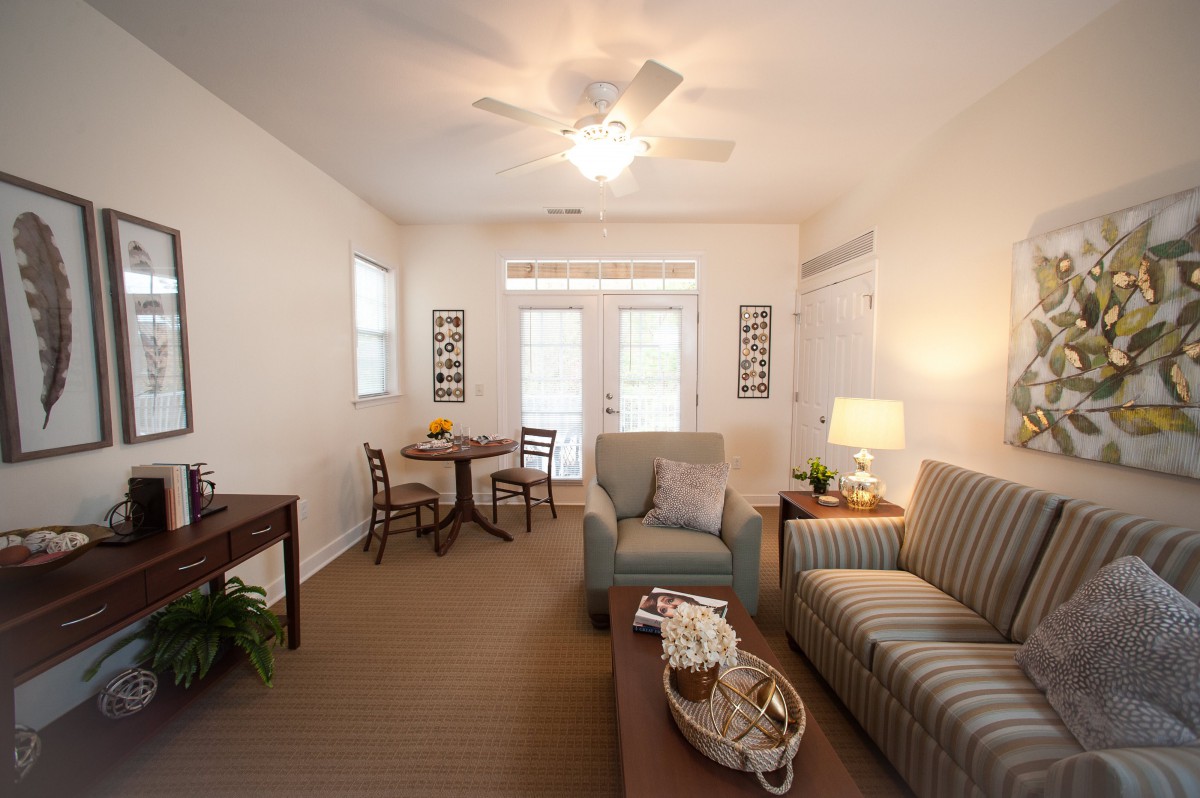 A cozy living room with comfortable seating, a round table, and ample natural light.