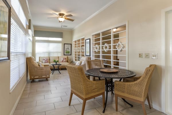 A cozy living space featuring wicker furniture and an organized bookshelves display.