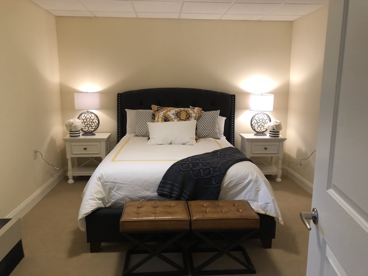A cozy and well-decorated bedroom with a double bed, flanked by two nightstands and lamps.