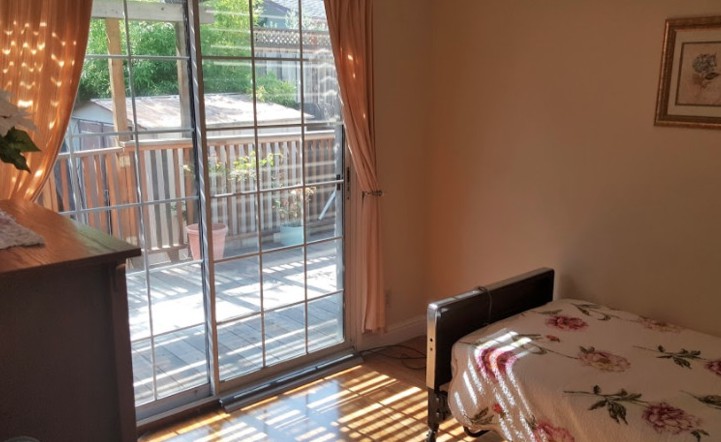 Sunlit room with sliding glass doors leading to a wooden deck.