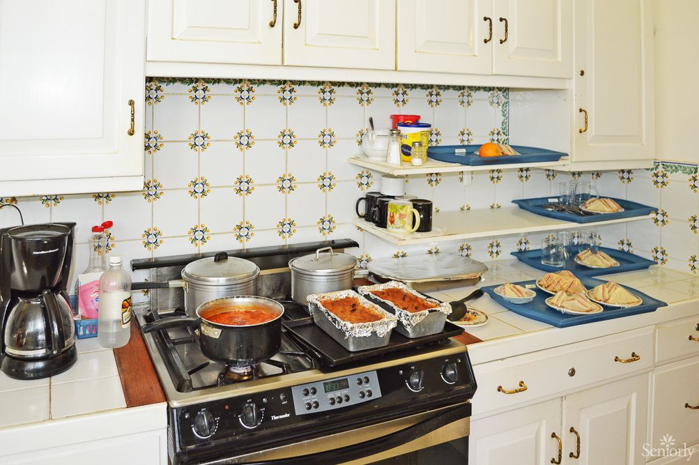 A busy kitchen scene with pots on the stove and loaf pans filled with ingredients.