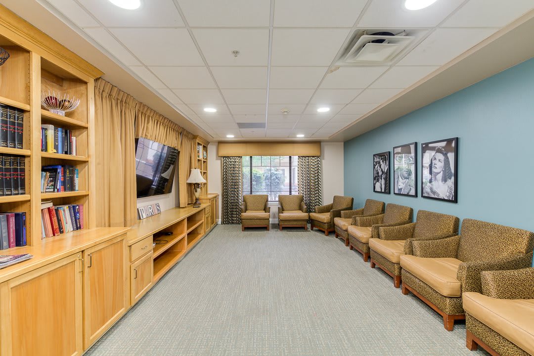 A modern living room with comfortable seating, a large television, and decorative artwork on the walls.