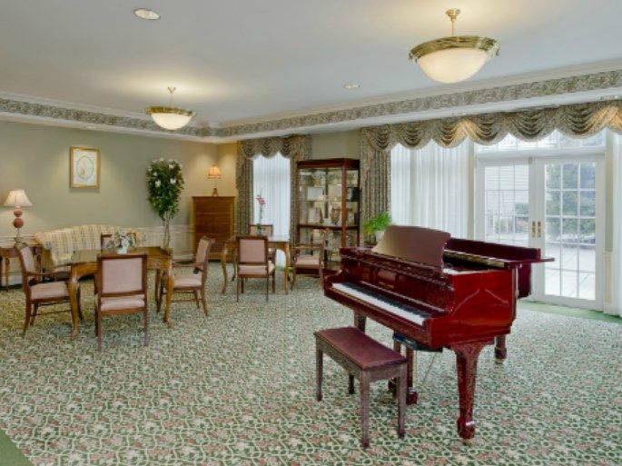 A well-furnished room featuring a grand piano and comfortable seating.