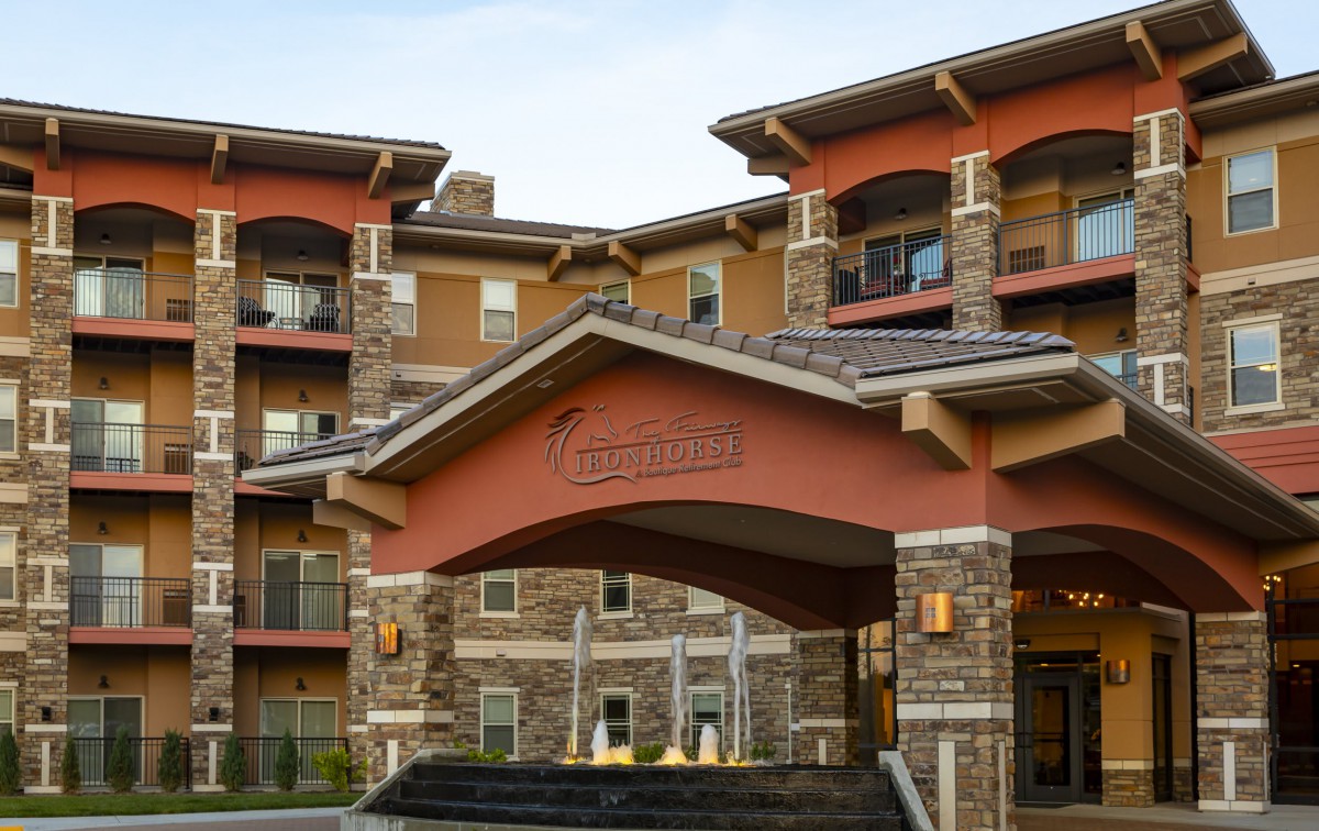 A modern residential building with a covered entrance and stone accents.