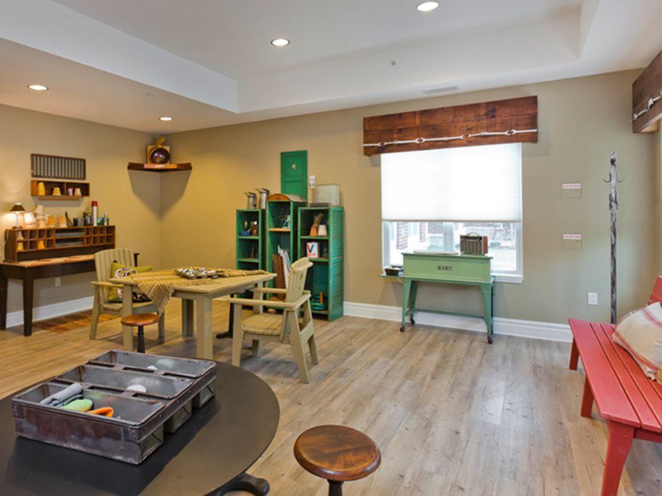 A cozy room with wooden floors, featuring a variety of furniture and decorative items.