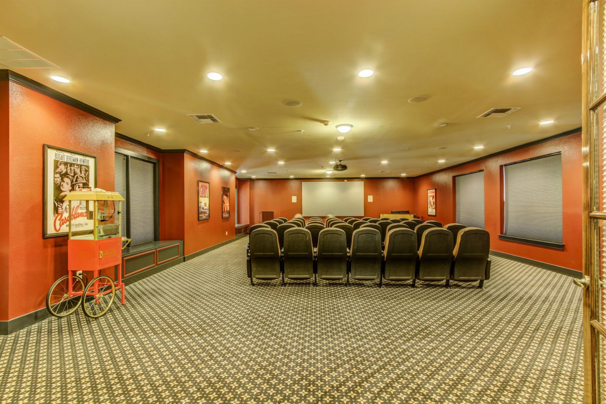 A theater-style conference room with rows of seating and a large projection screen.