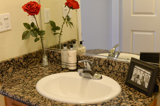 A well-decorated bathroom sink area featuring elegant roses and a granite countertop.