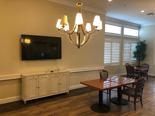 A cozy living space featuring a chandelier, a television, and a dining table.