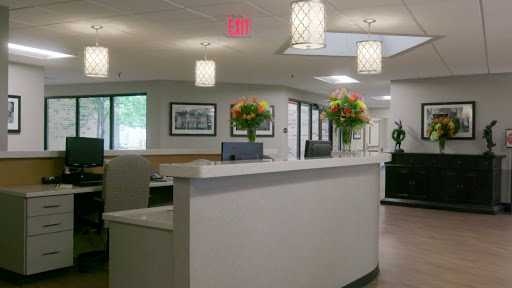 A welcoming reception area featuring modern decor, bright lighting, and floral arrangements.