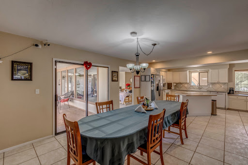 A bright and inviting dining area with a large table and comfortable chairs, perfect for family gatherings.