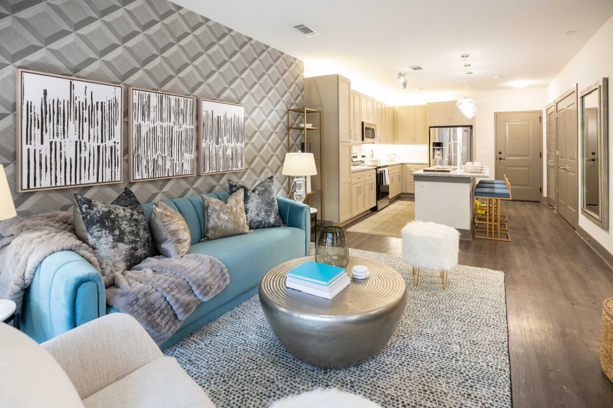 A modern and cozy living room with an open floor plan leading to the kitchen.
